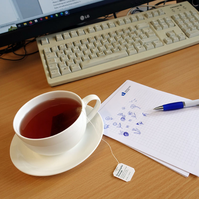 Monitor, Tastatur, Tee, Notizblock, Stift, Auf dem Schreibtisch